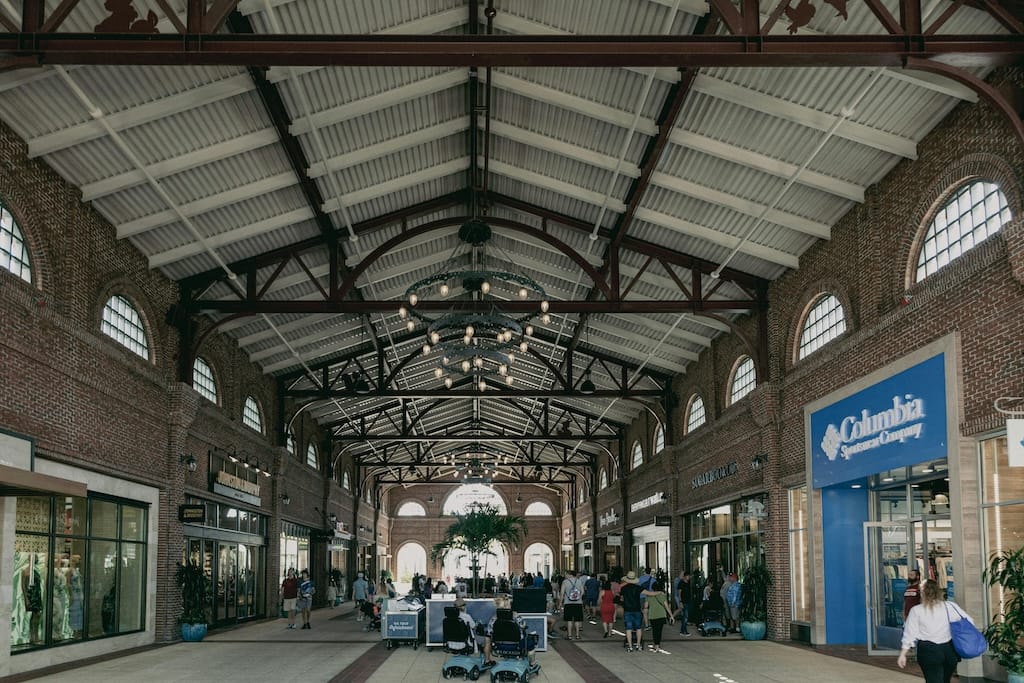 Modern shopping mall interior with empty retail kiosks and temporary spaces available for lease, showing high ceilings and natural light